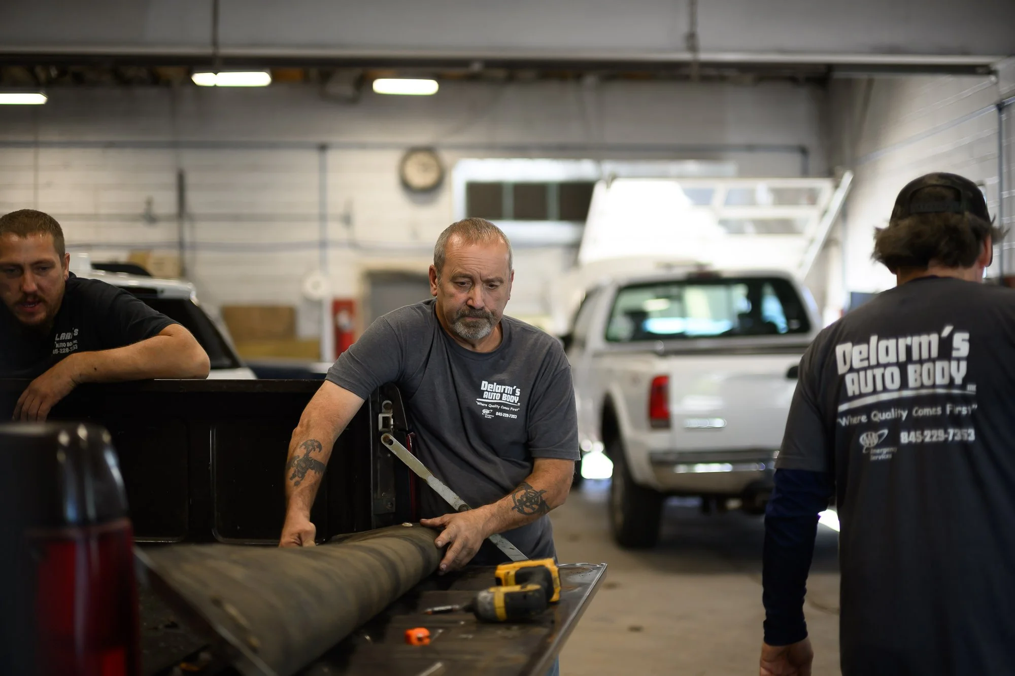 Three Delarm's technicians working together in the repair bay