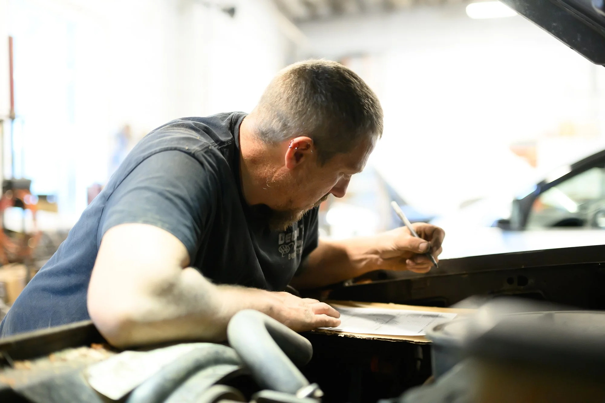 Schyler inspecting a car body panel up close