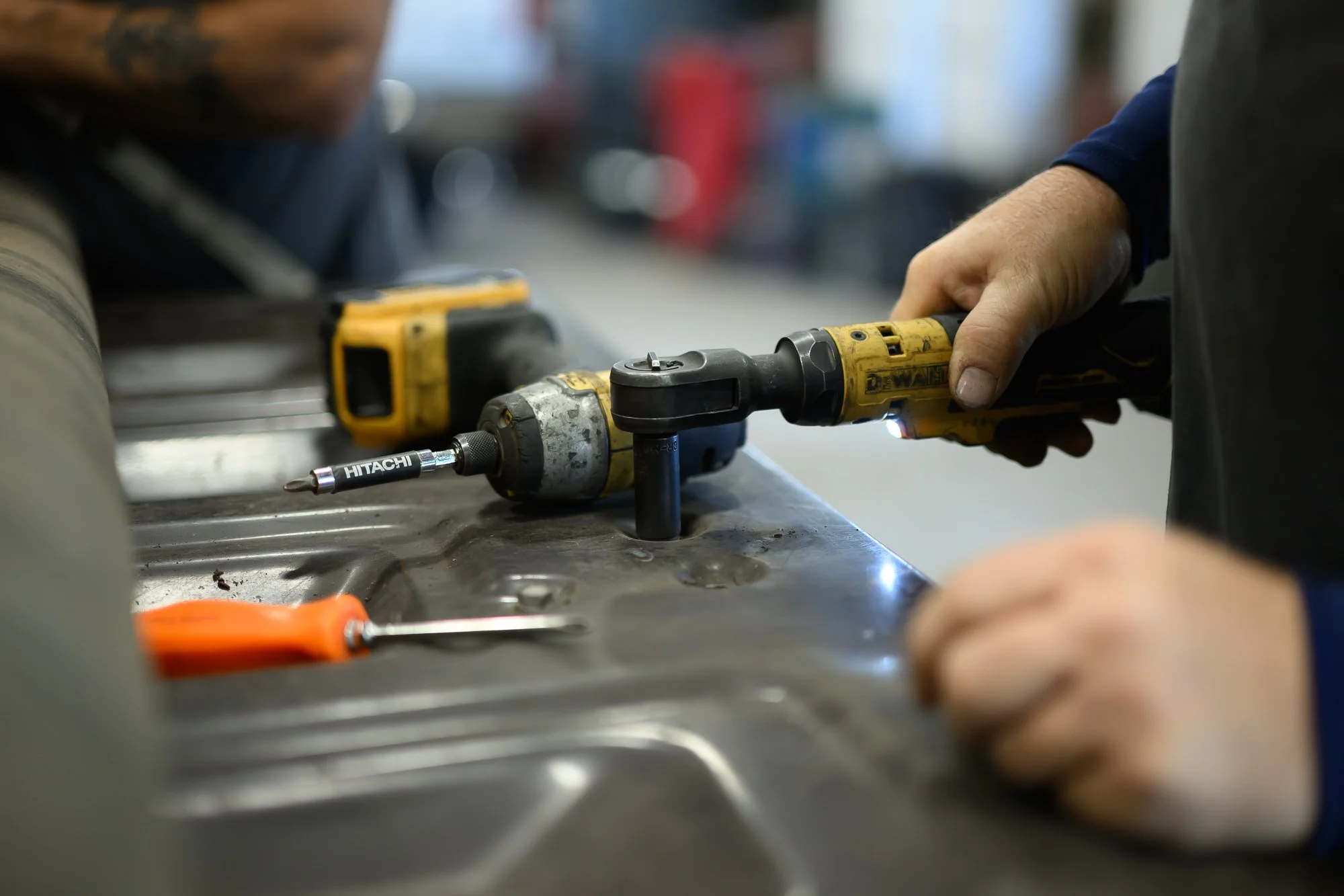 Technician driving a fastener with a cordless impact driver at Delarm's Auto in Hyde Park, NY