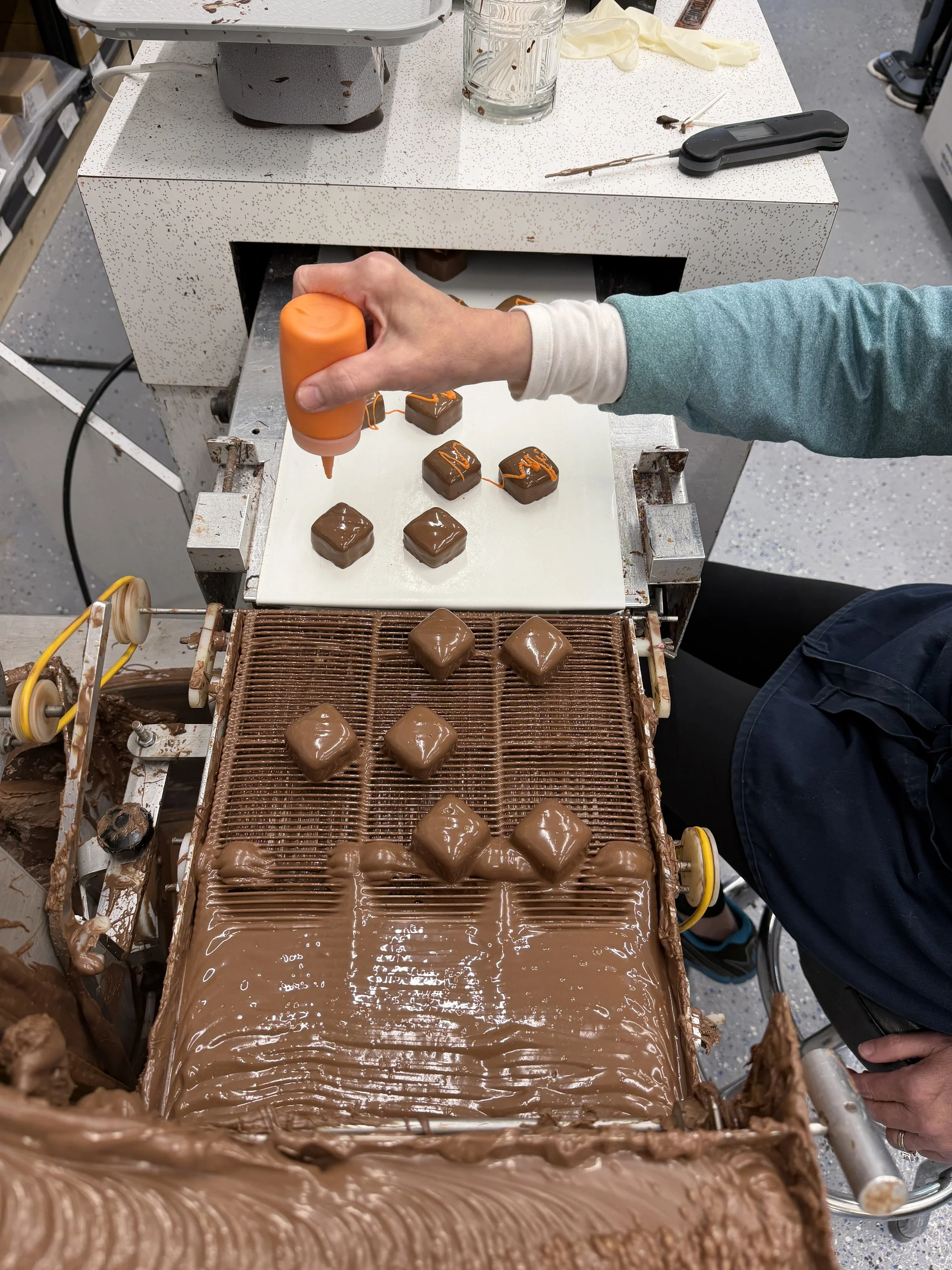 employee drizzling chocolate