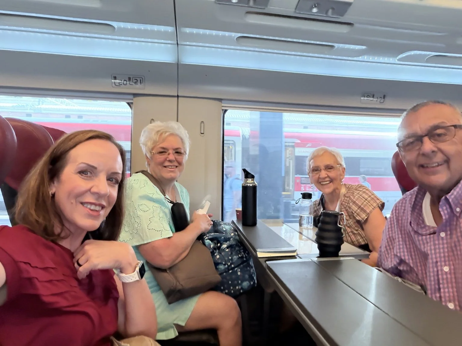 Family traveling together aboard an Italian passenger train during a multi-city Italy vacation