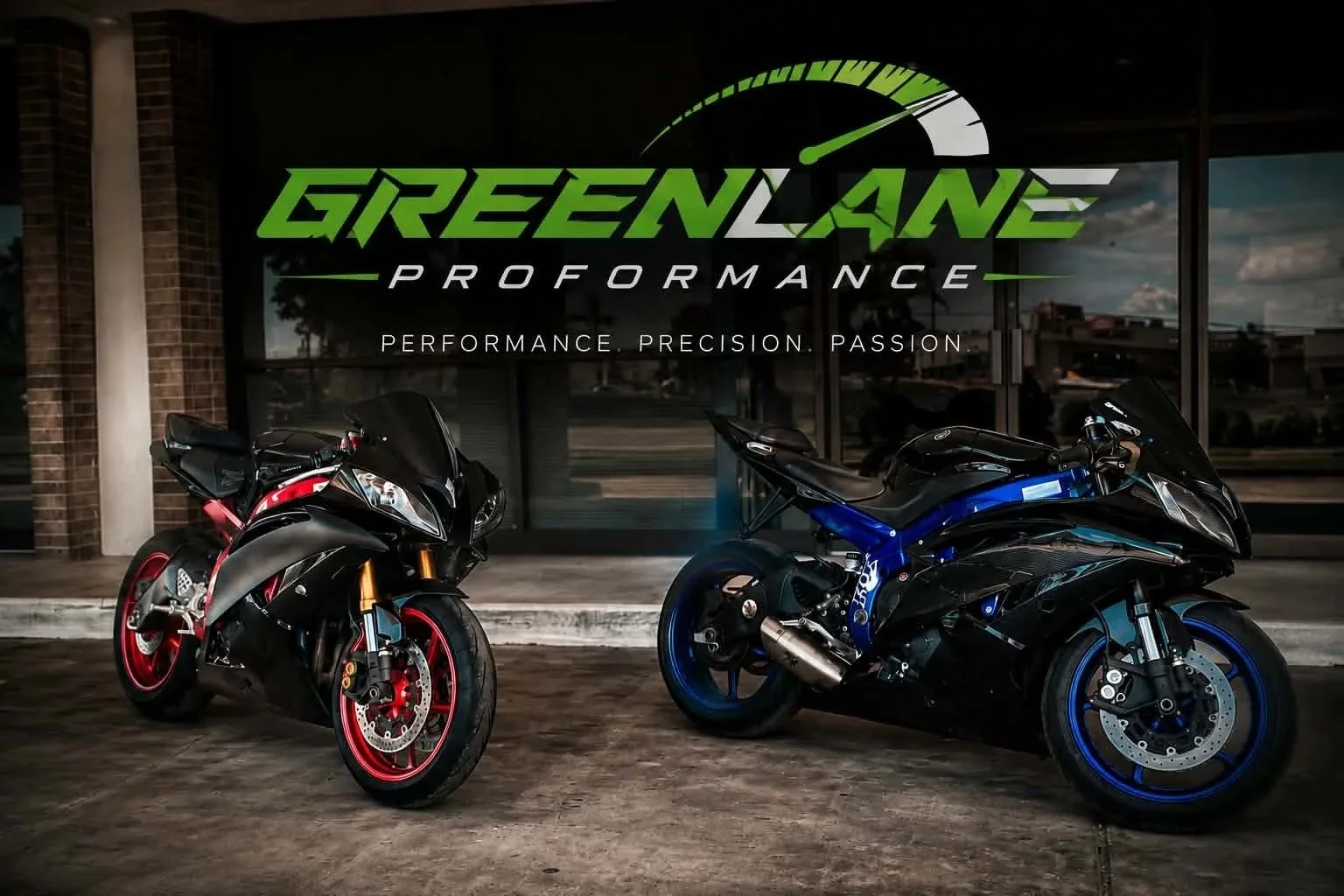 Two sport motorcycles parked outside of Green Lane Performance, with a brick wall and glass window behind them, and the Green Lane Performance logo with slogan overlayed at the top.