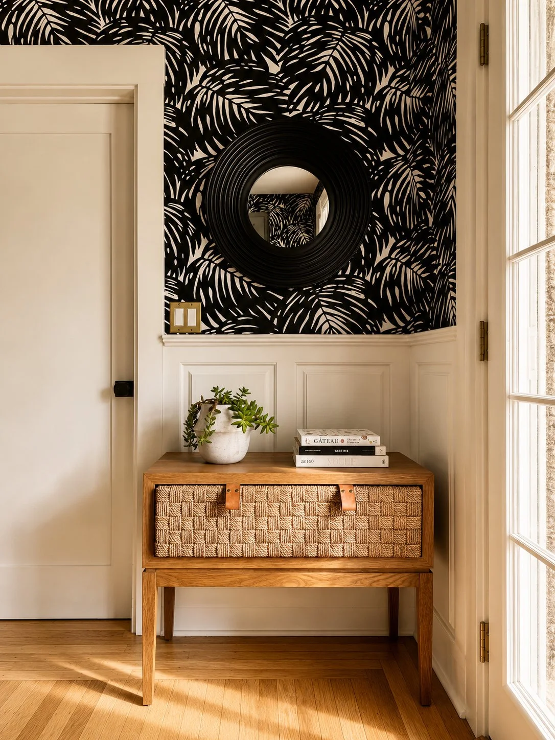 Stylish entryway by Aster & Aire featuring bold patterned wallpaper, a round statement mirror, natural wood furniture and layered interior styling, showcasing approachable interior design in San Anselmo, Marin County.