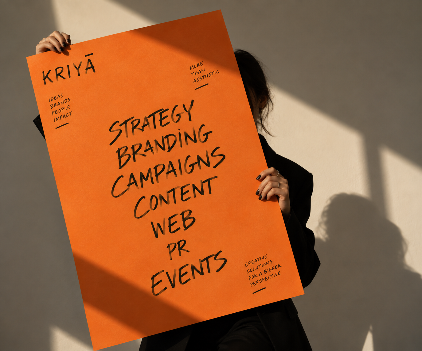 Pessoa segura painel da Kriyā Projects com serviços de estratégia, branding, campanhas, conteúdo, web, PR e eventos.