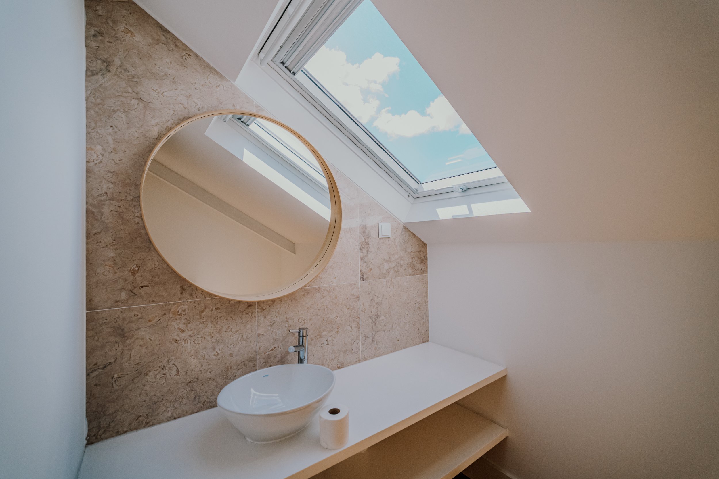 Natural light, warm stone and clean lines define this residential interior near El Corte Inglés, Lisbon.