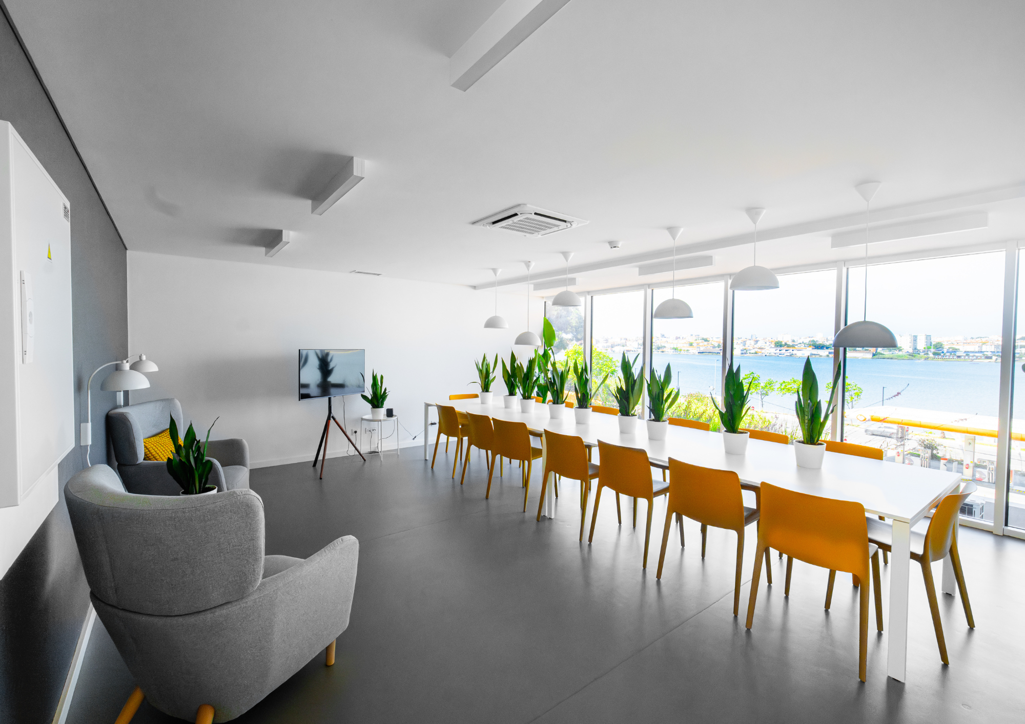Wide framing connects the interior with the river view, reinforcing openness and location.