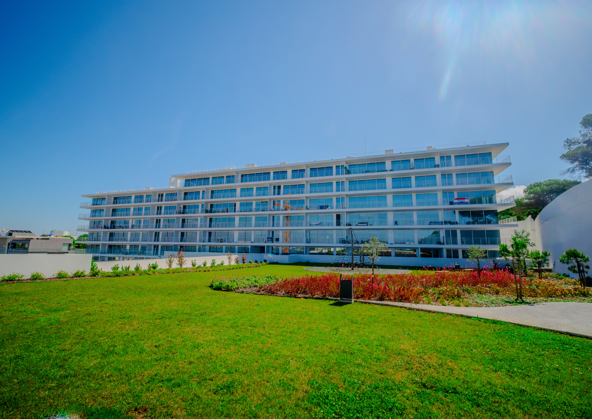 Low-angle exterior shot highlights the building’s scale, geometry and landscaped setting.