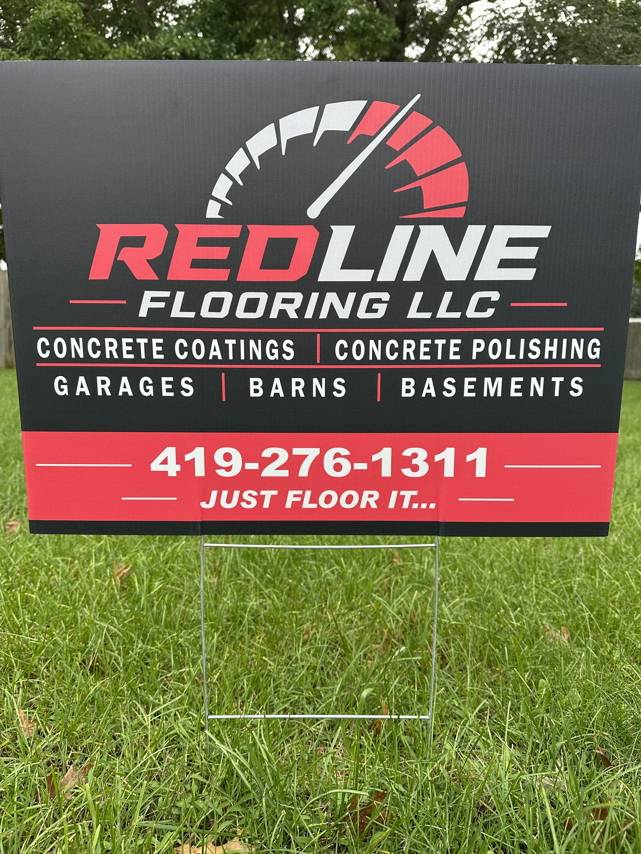 Sign for Red Line Flooring LLC advertising concrete coatings, concrete polishing, garages, barns, and basements, with a phone number and slogan 'Just Floor It.'