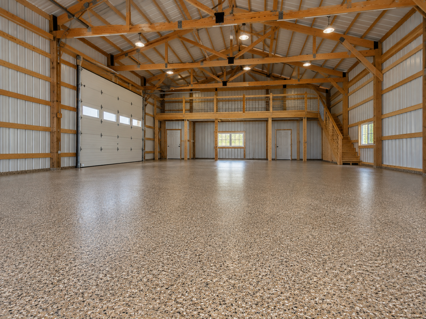 Empty spacious garage with polished concrete floor, metal walls, wooden beams, and a loft with staircase. Includes garage door, windows, and interior doors.