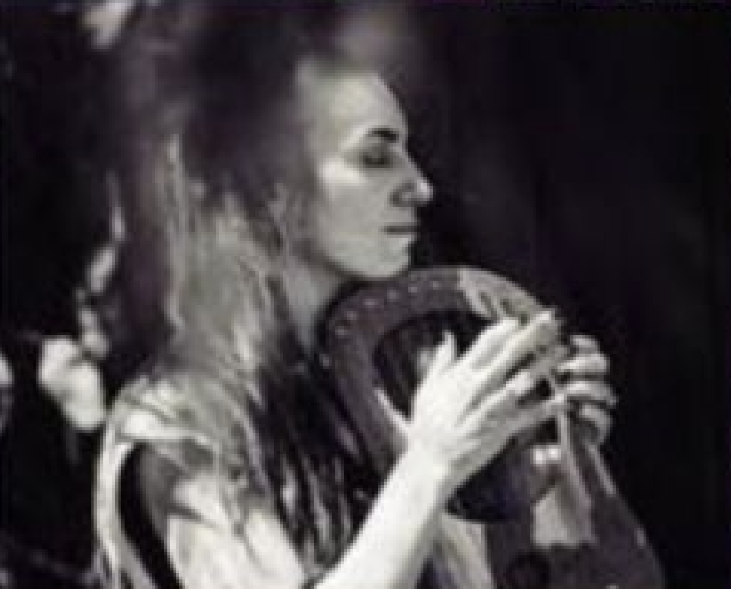 Joven tocando música en un micrófono en un entorno oscuro.