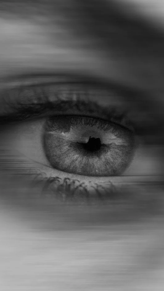 Nahaufnahme eines menschlichen Auges in Schwarzweiß, das Details wie Iris, Pupille und Wimpern zeigt.