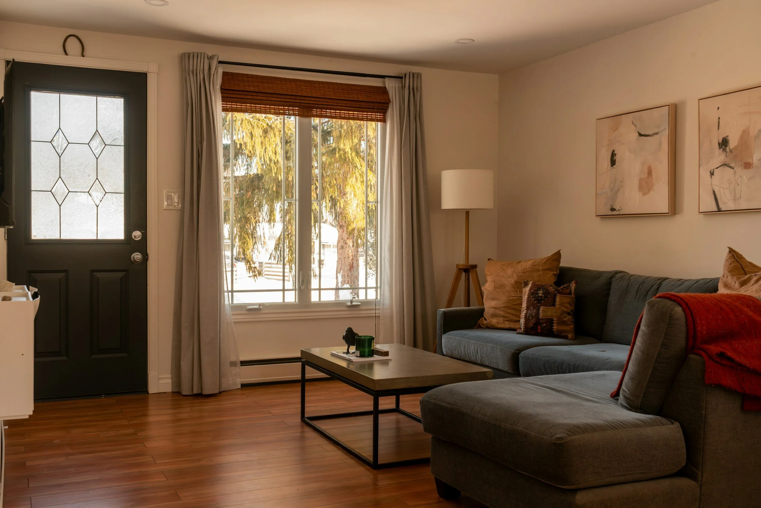 Cozy furnished living room with large windows and natural light