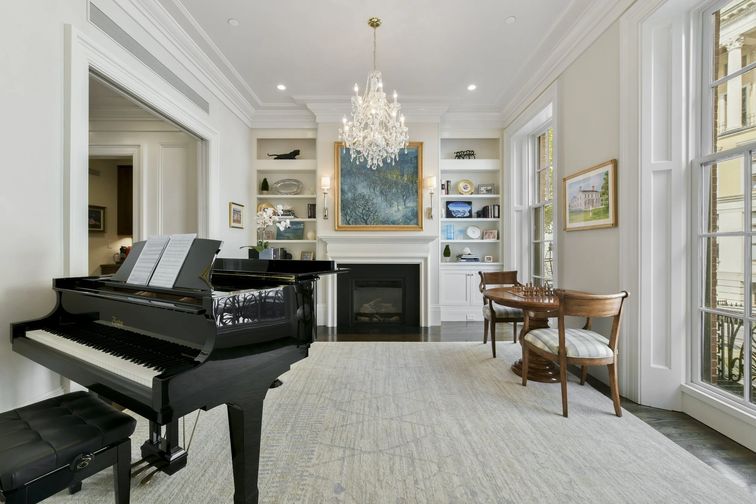Beacon Hill, Boston living room with a grand piano, chandelier, built-in bookshelves, and large windows.
