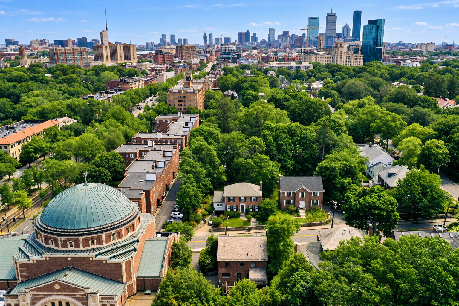Aerial view of Brookline, Massachusetts, featuring tree-lined neighborhoods and the Boston skyline in the distance.