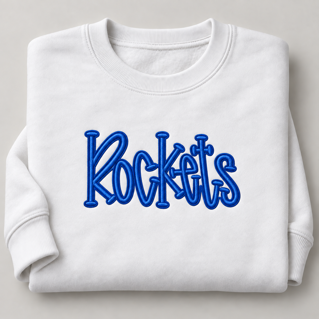 Centered smaller Rockets embroidery on white sweatshirt.png