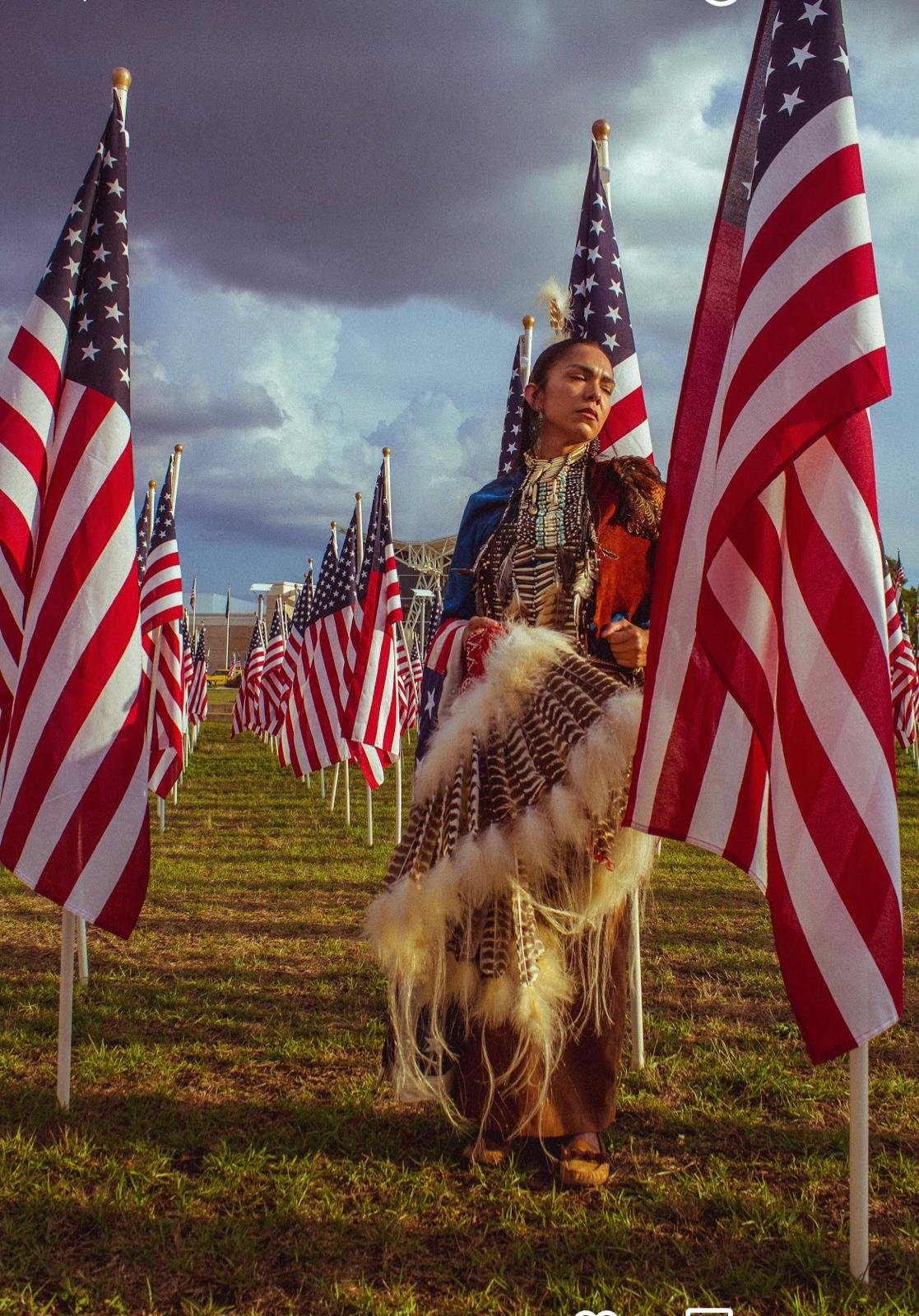 Sara representing Native American culture at a Memorial Day community event with American flags