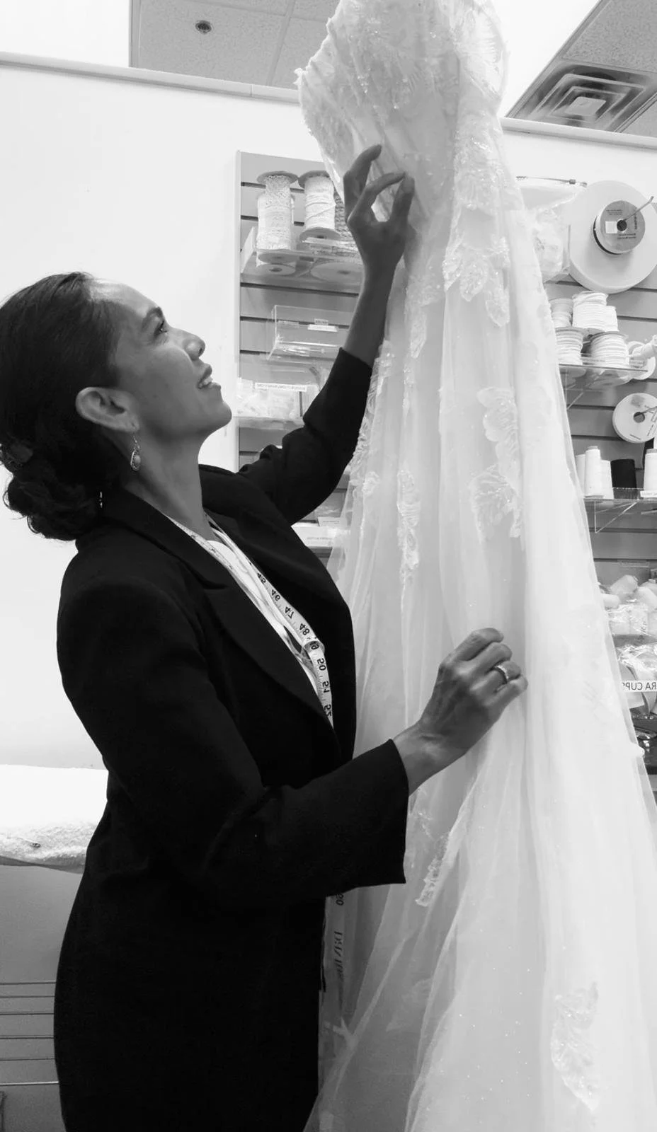 Bridal gown being inspected for professional wedding dress alterations and fitting.