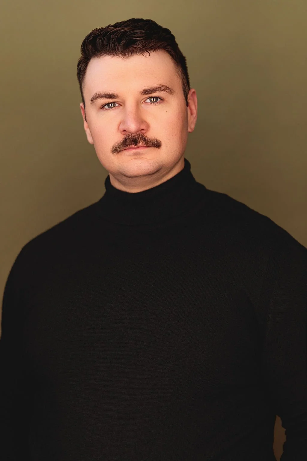Chris Gallerani - Tenor, smiling in a black turtleneck. Headshot by Benjamin Rose Photography.
