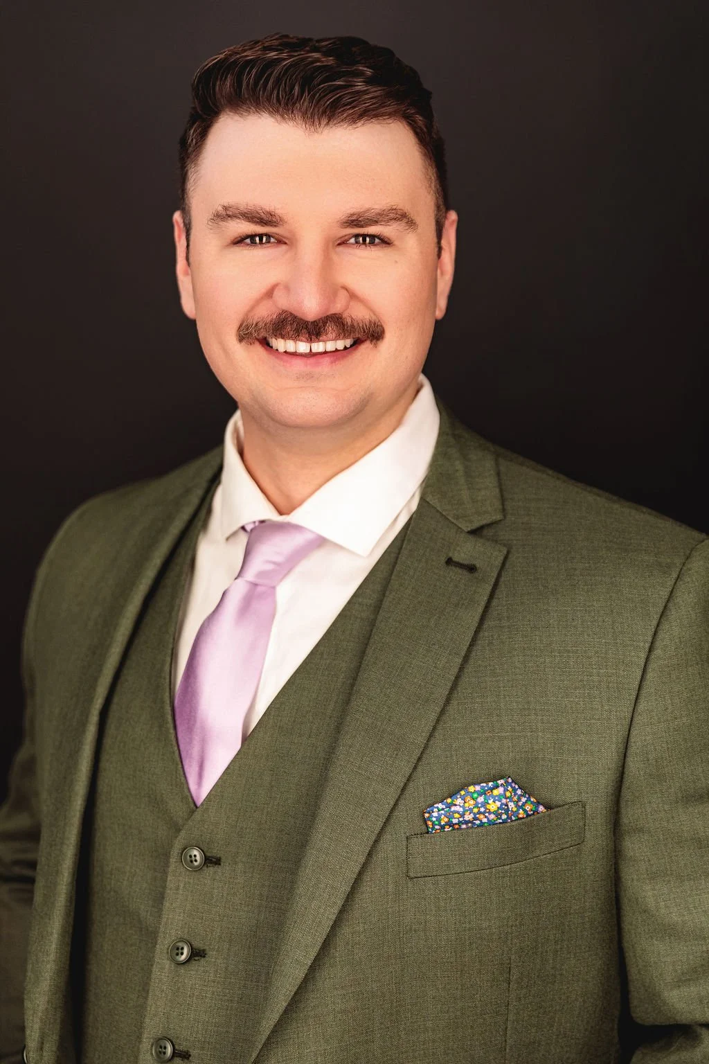 Chris Gallerani - Tenor, smiling in a suit. Headshot by Benjamin Rose Photography.