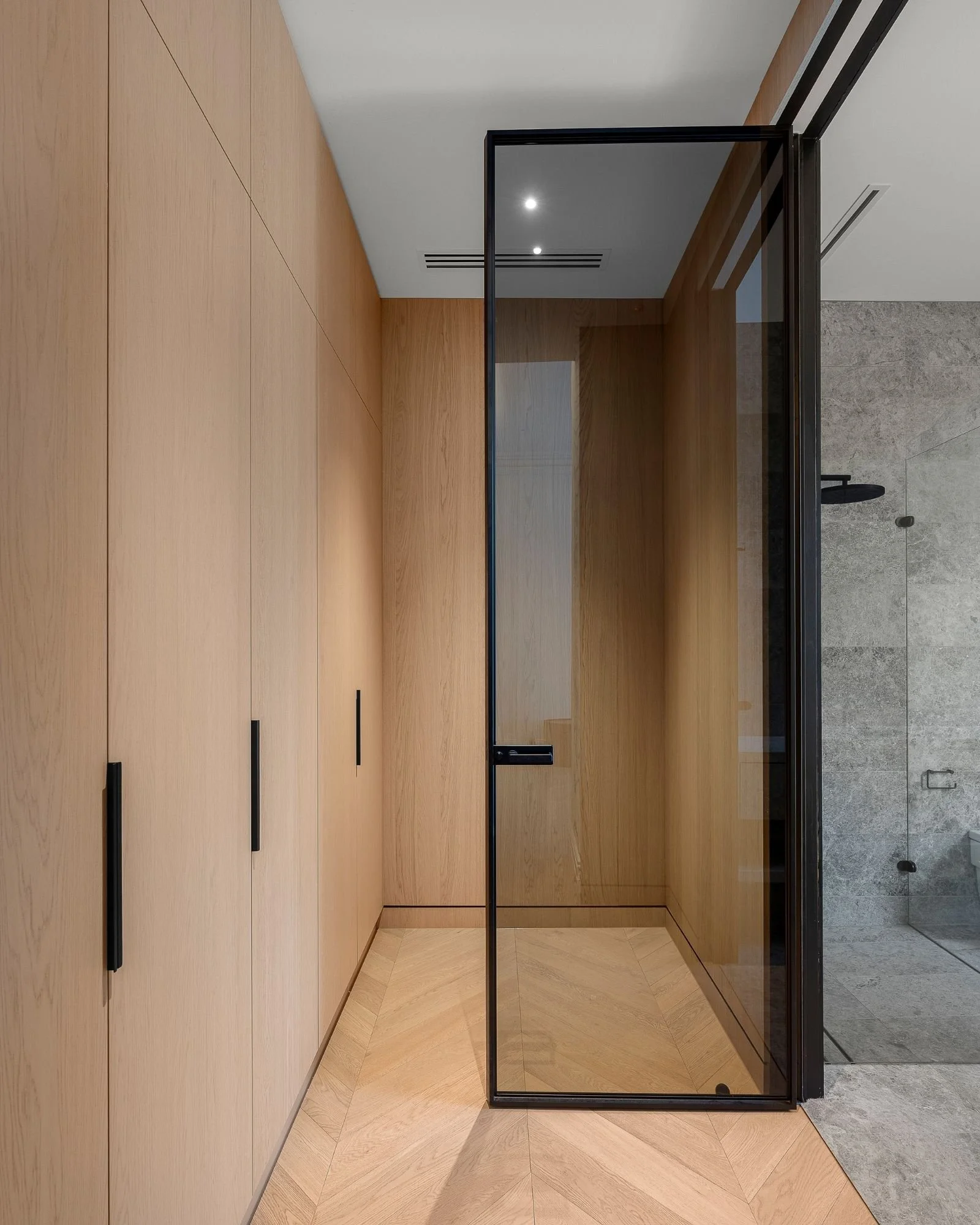 Modern interior with wooden wall panels, a glass partition, and tile flooring, possibly in an office or residential space.