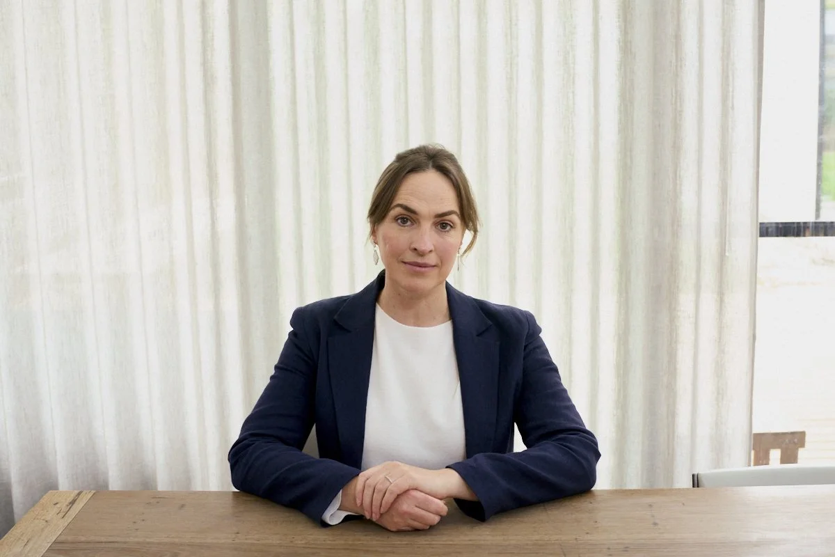 Lawyer sitting at a table with arms folded in front