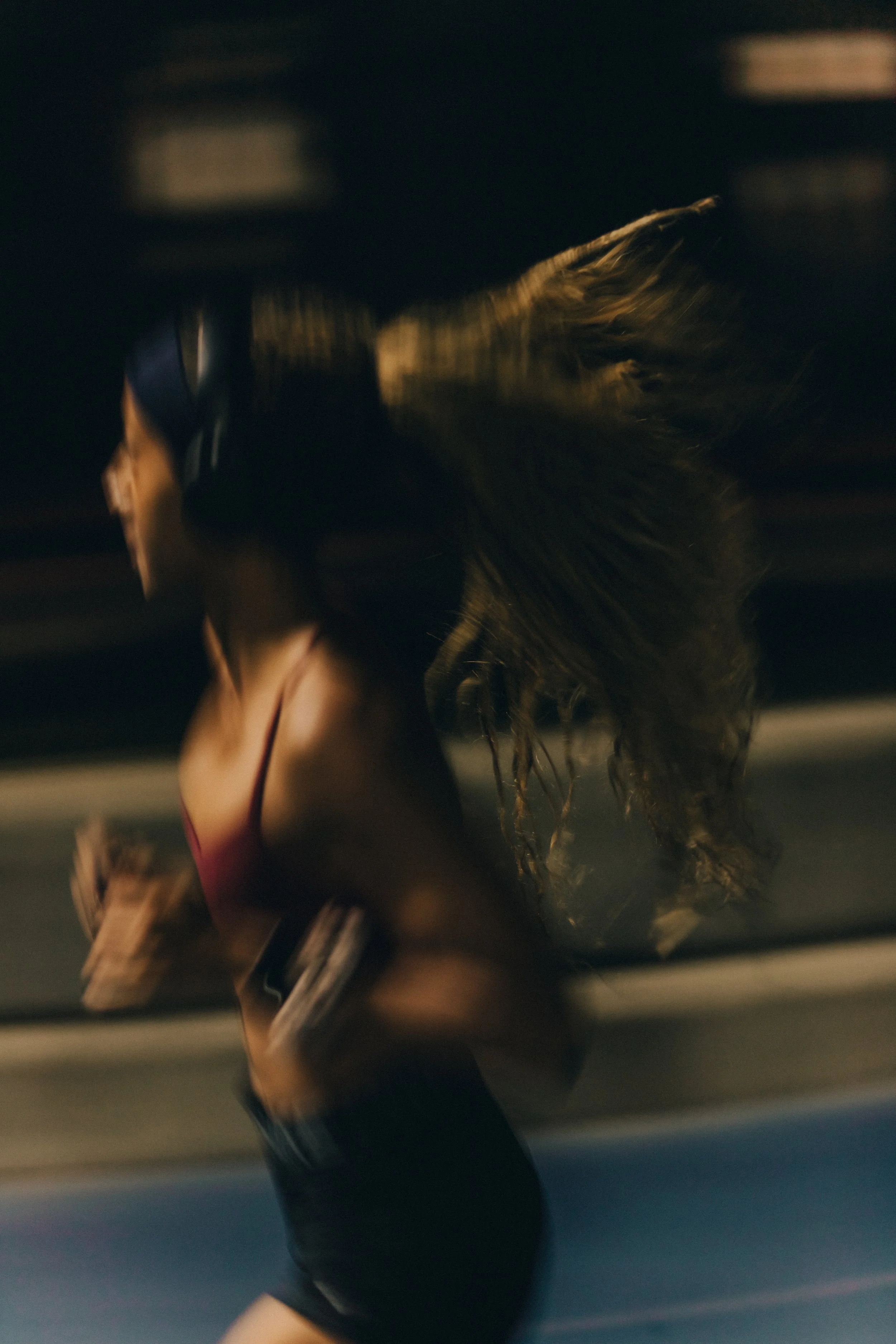 Blurred close-up of a woman with wet hair in a dimly lit indoor setting