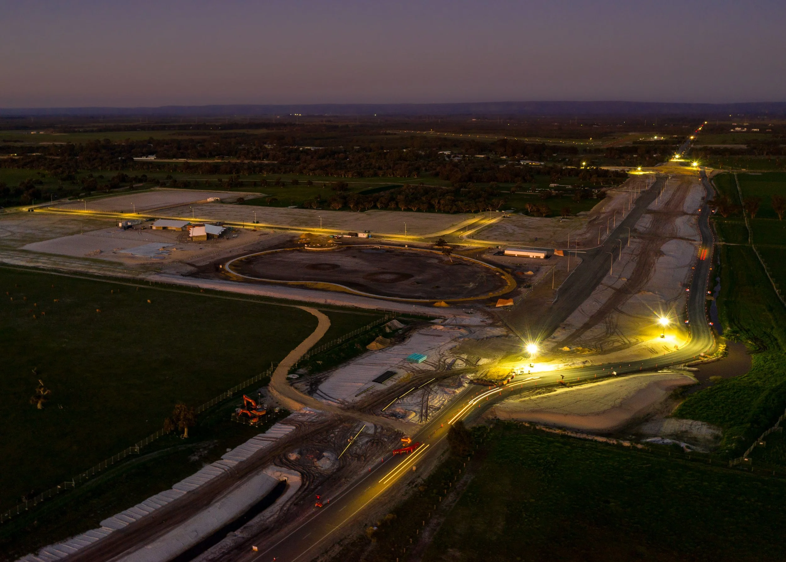 Aerial view of a large construction and infrastructure site photographed at dusk