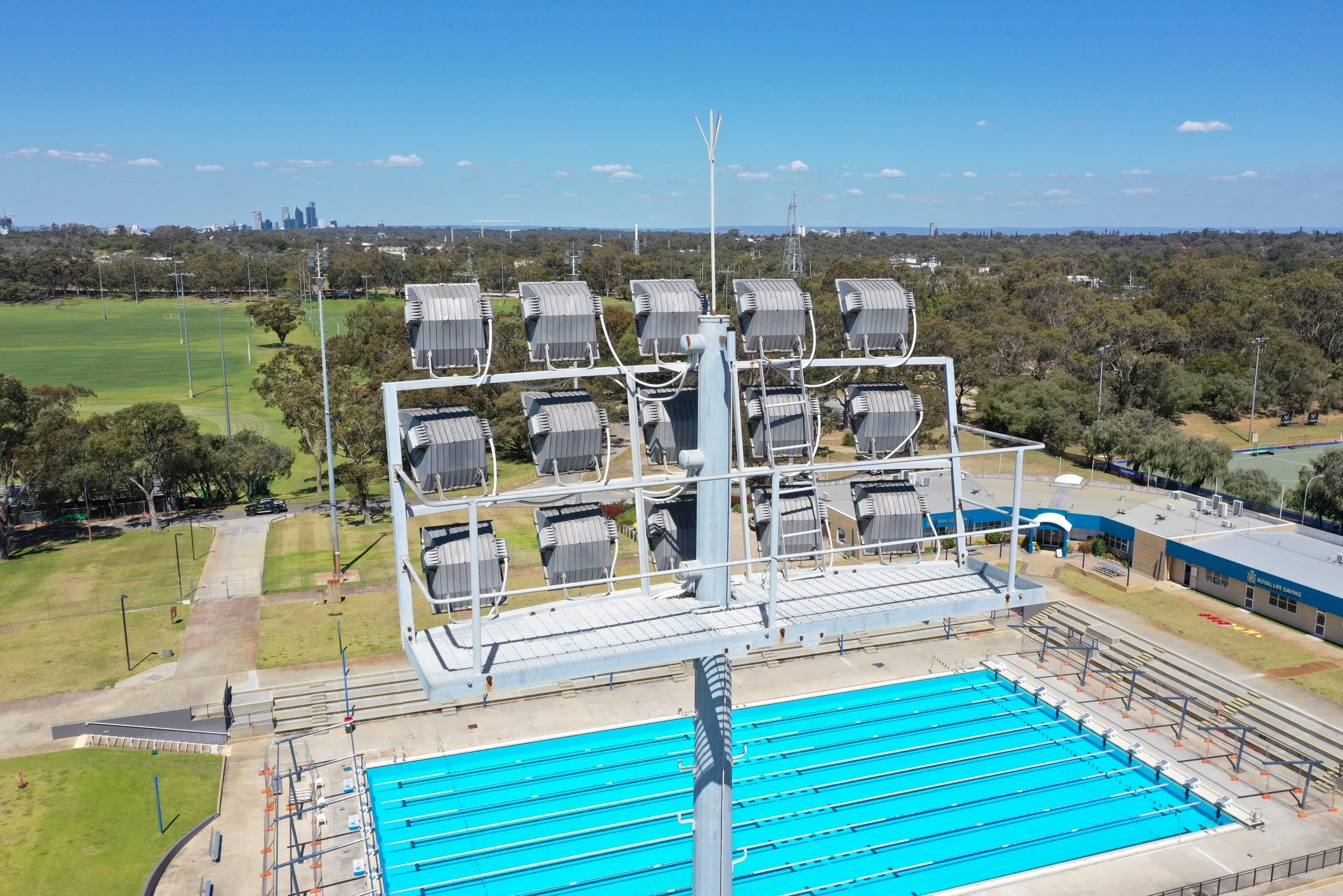 Drone close up inspection imagery of light tower mounting points before an LED upgrade at an aquatic facility