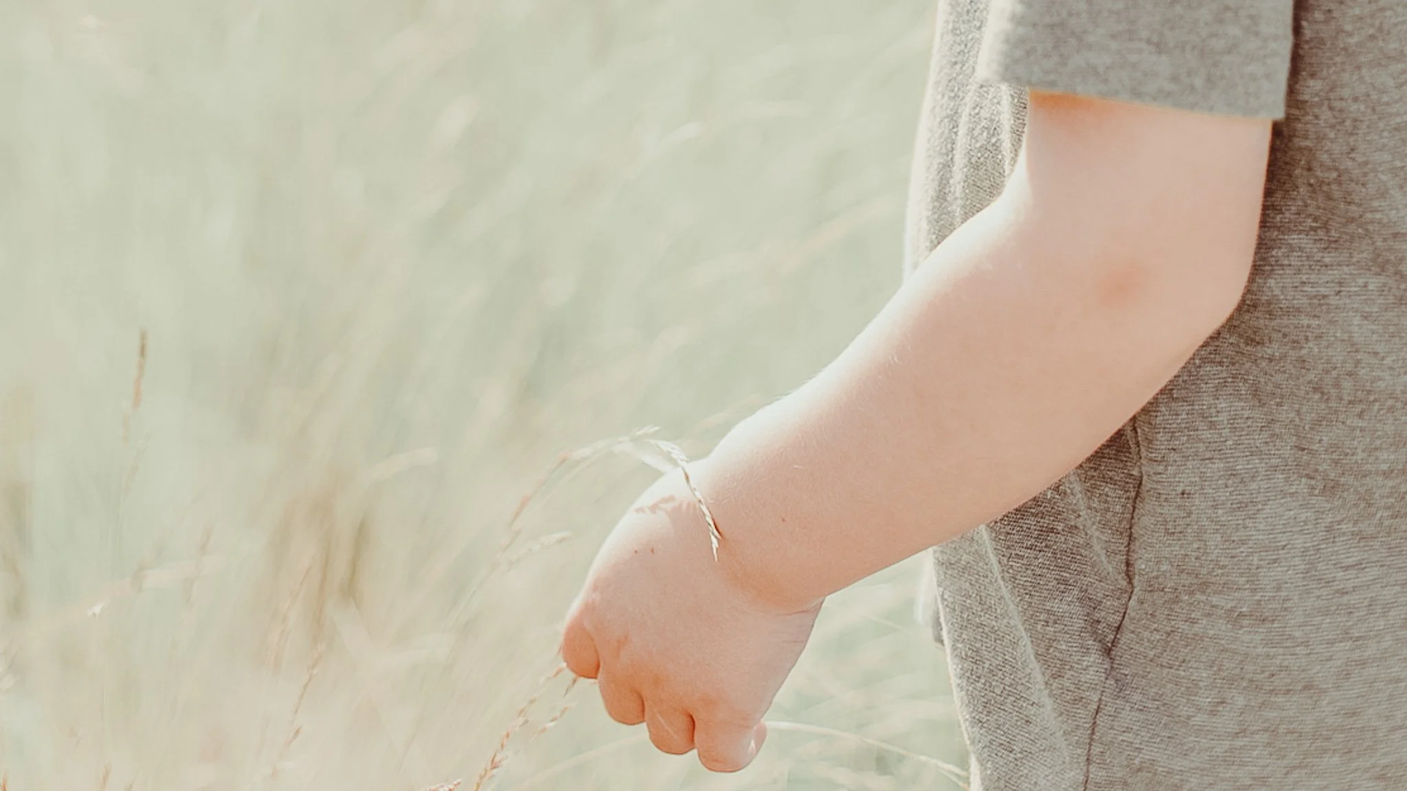 toddler boy in tall grass neutral colors cottage feel vibe