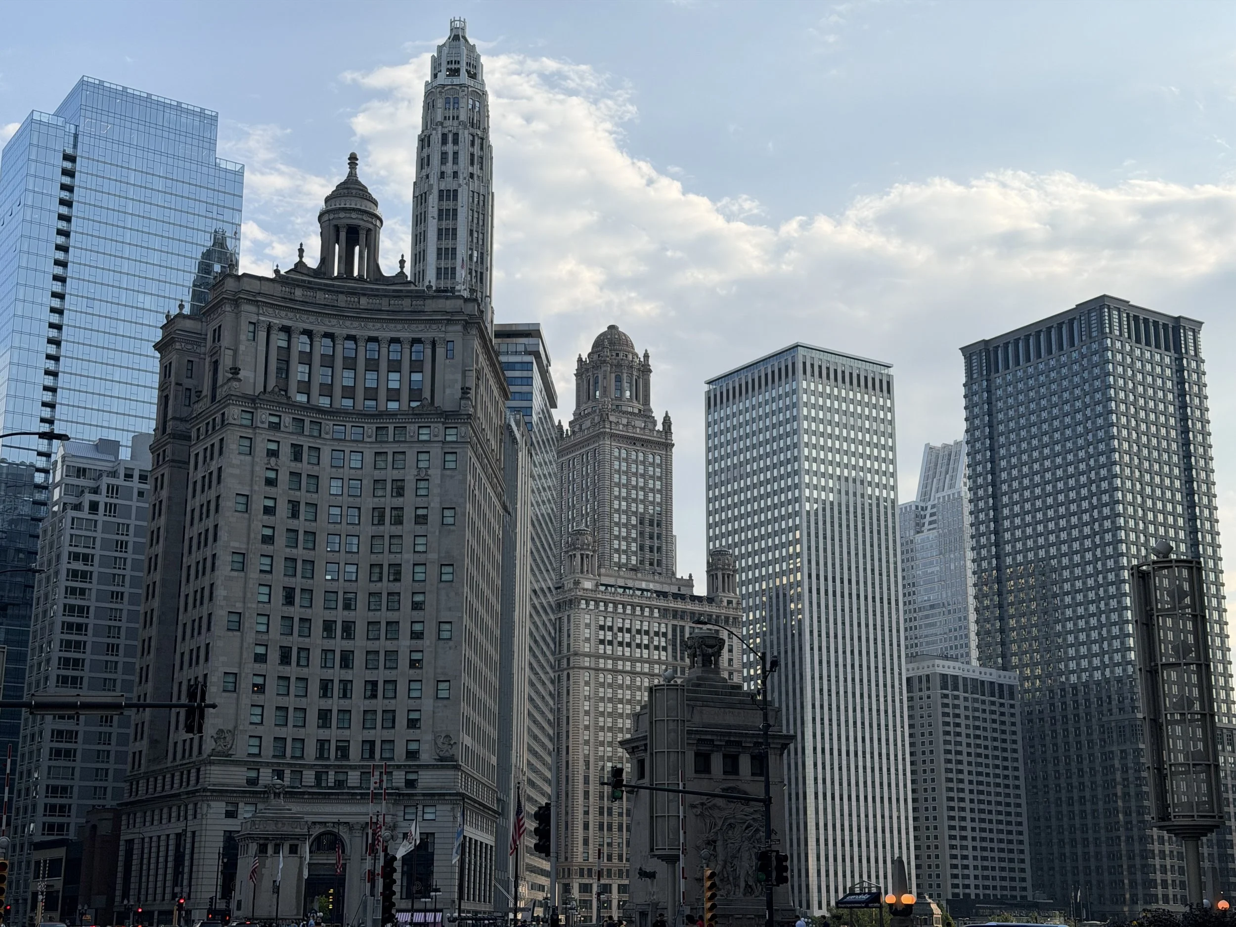 Cityscape with tall skyscrapers under partly cloudy sky in downtown area.