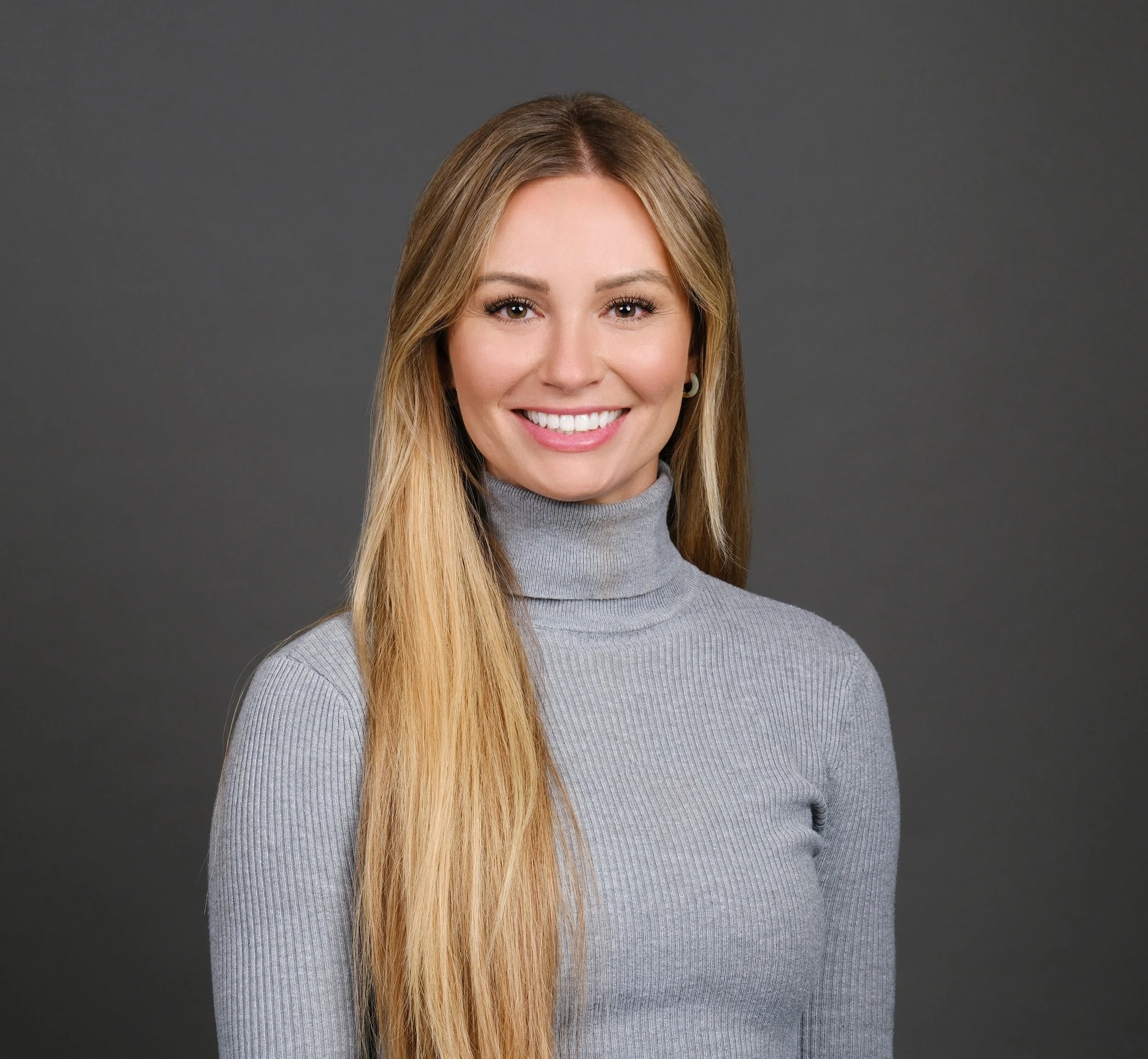 Headshot of smiling female prof with long braids wearing a lanyard.
