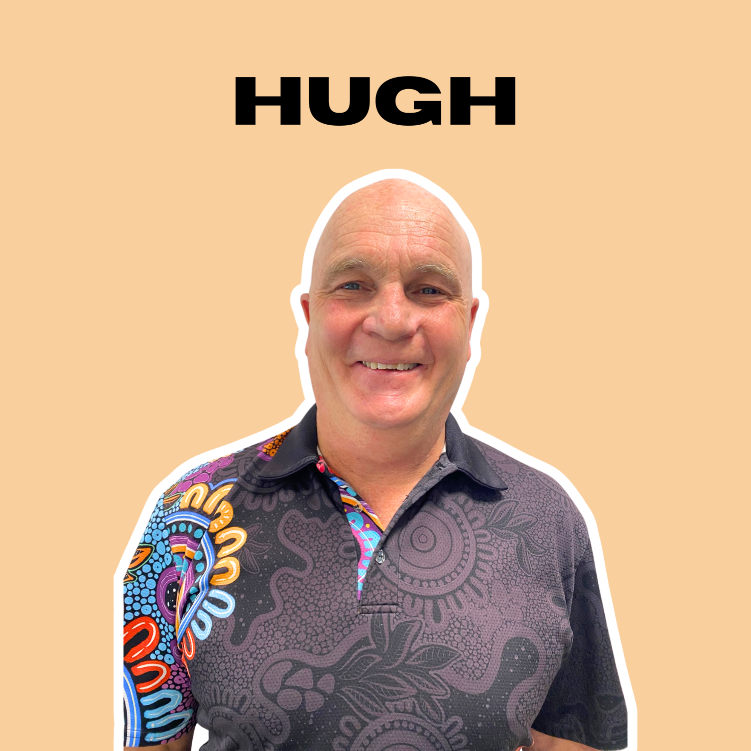 A smiling bald man wearing a black shirt with colorful patterns on the sleeve and chest, standing against a peach-colored background with the name 'HUGH' written above his head.