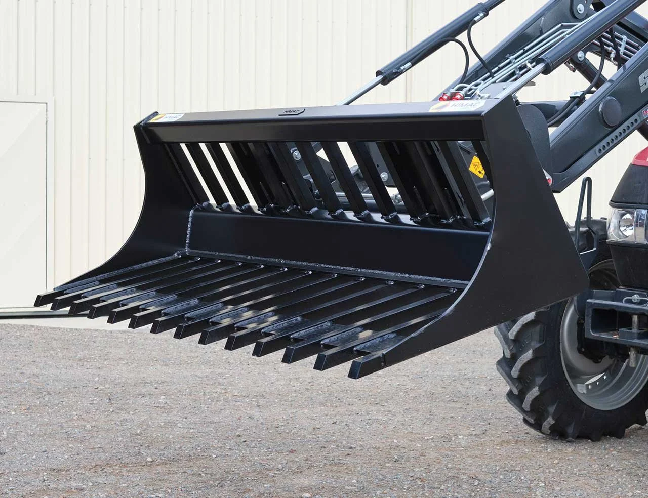 HIMAC power rake bucket attachment on a tractor loader