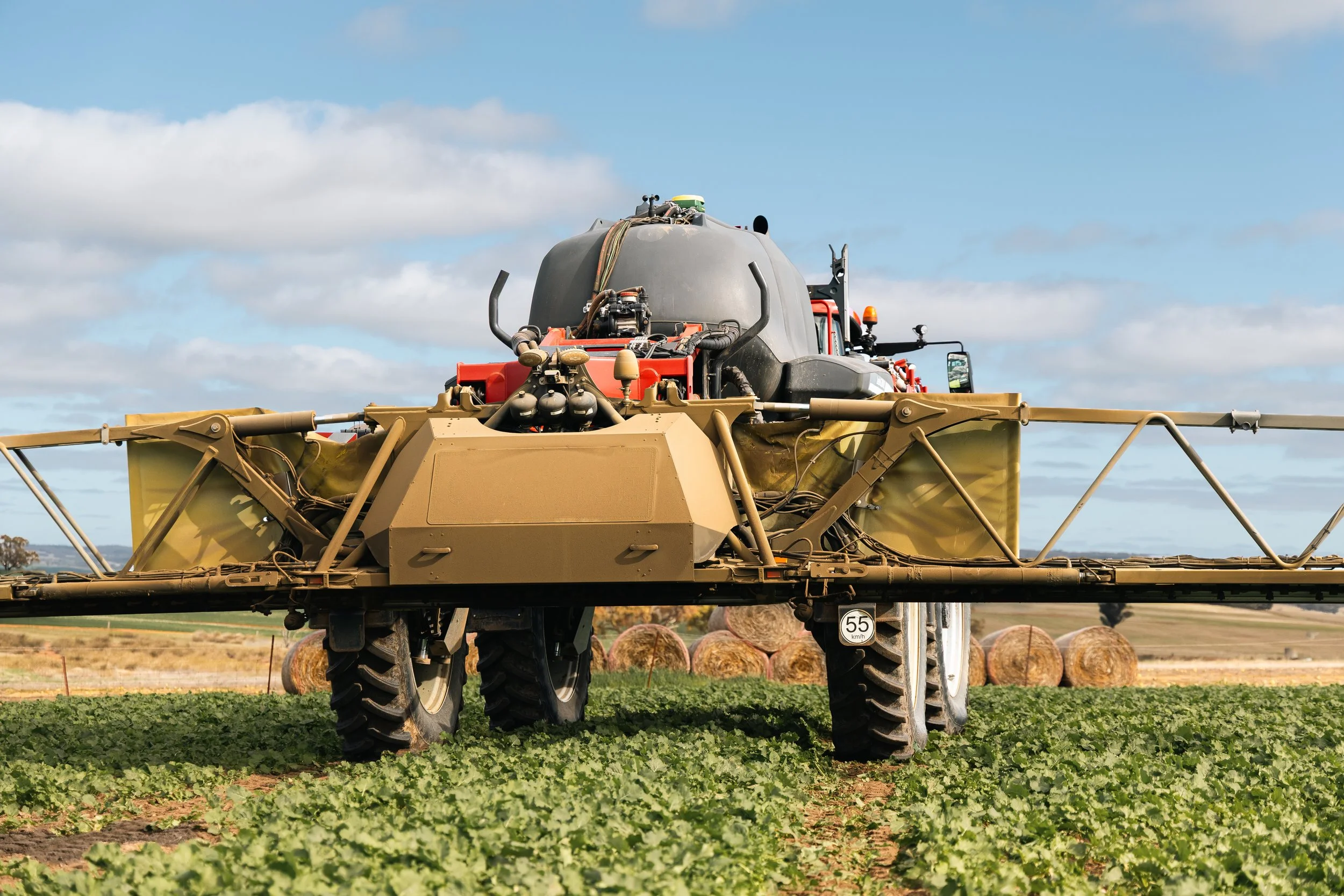 Rear view of a HORSCH Leeb SP sprayer boom and tank in a green crop