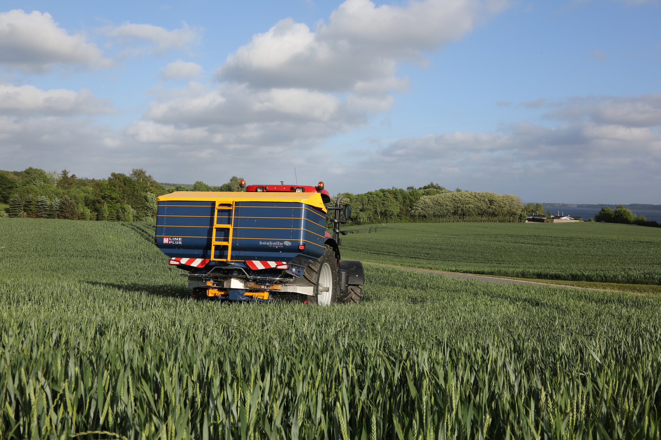 Bogballe M45W fertiliser spreader working in a green cereal crop