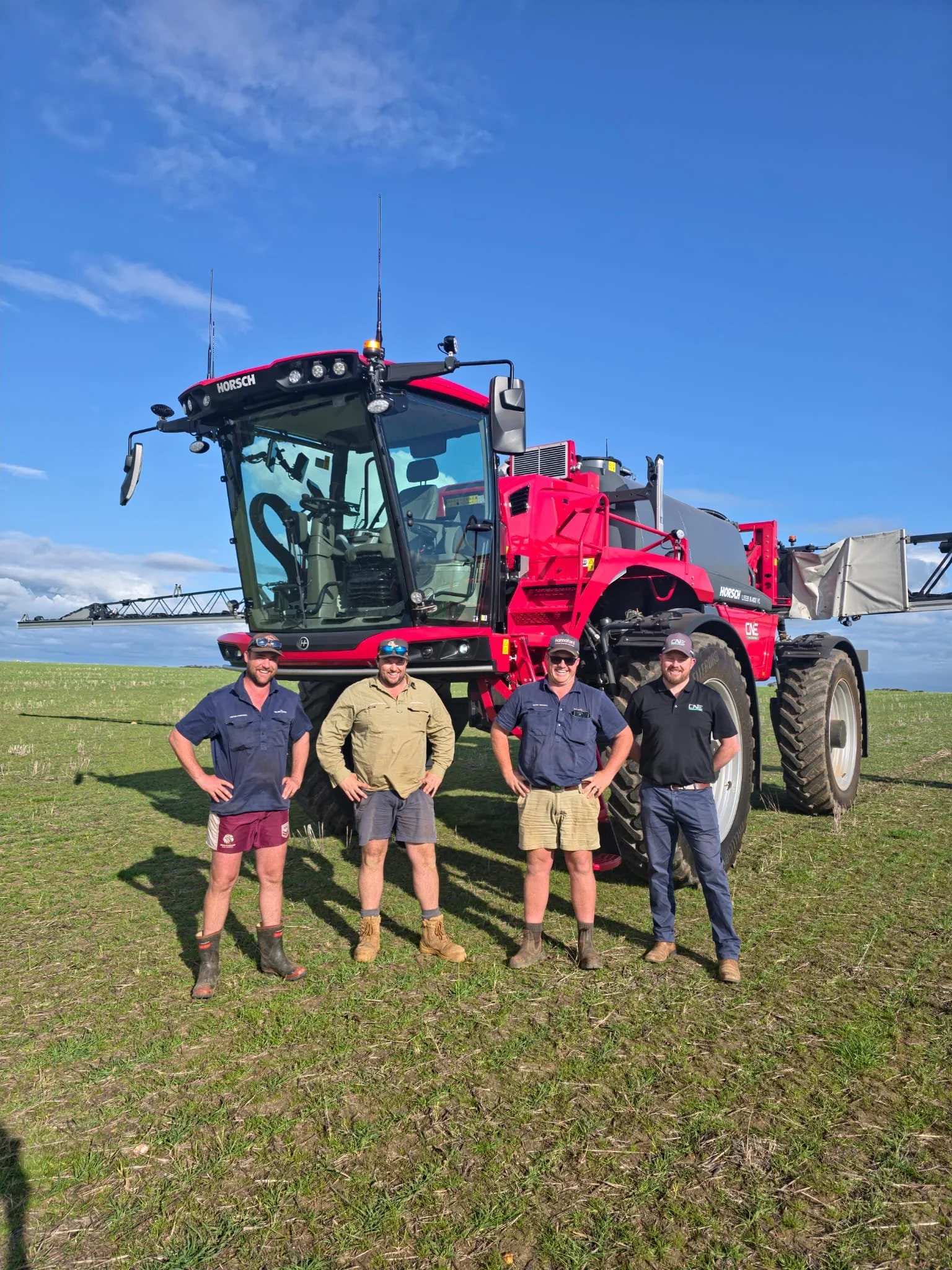 Four men standing in front of a HORSCH Leeb SP sprayer in a paddock