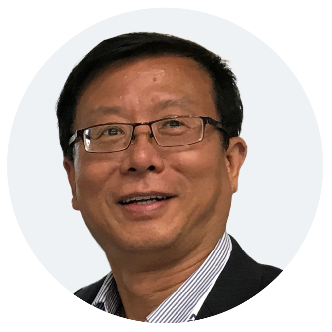 Smiling man with glasses in a suit and striped shirt.