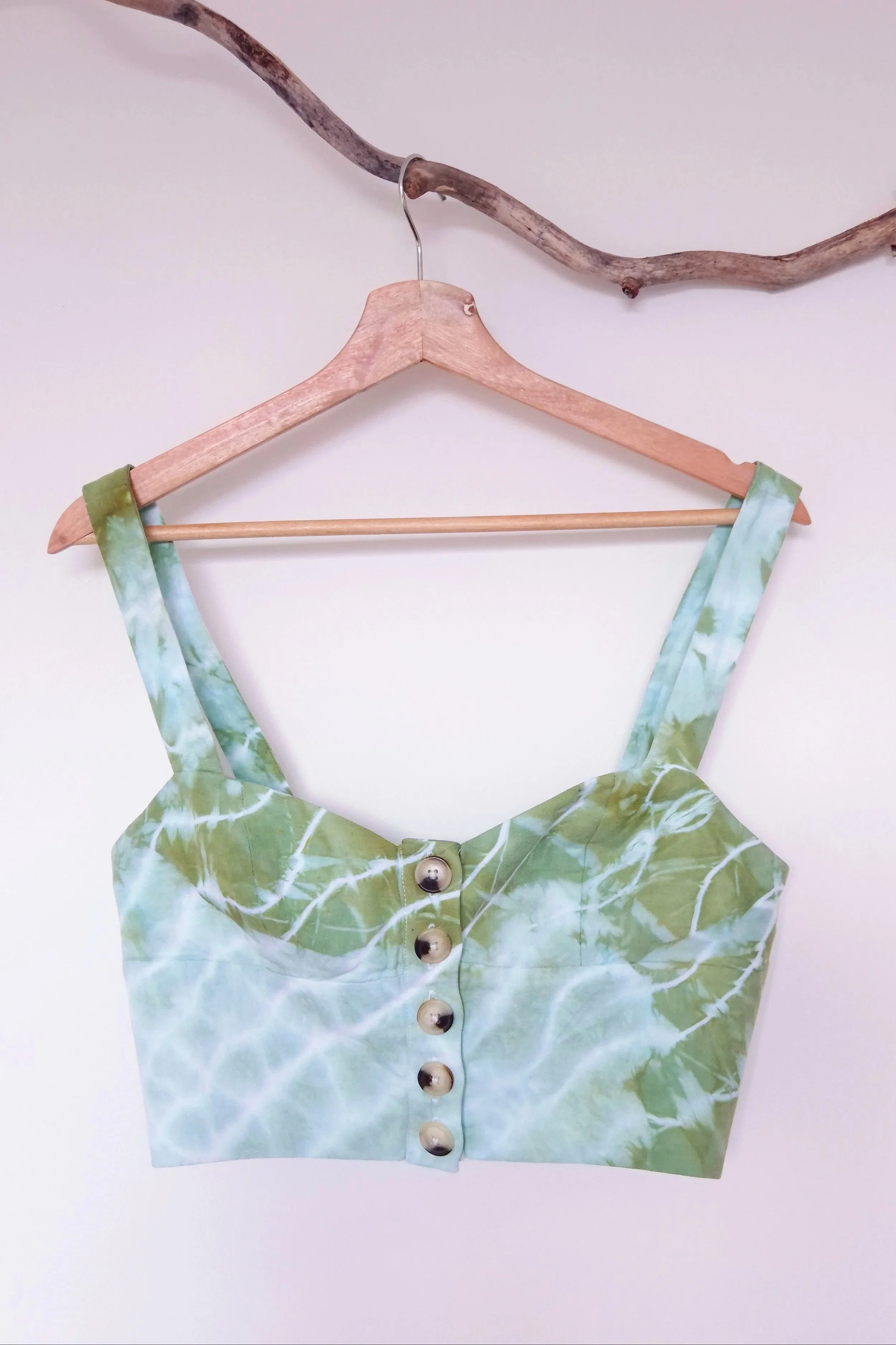 GUM LEAF, a hand-dyed soft green bustier crop top with white leaf-vein lines and statement buttons