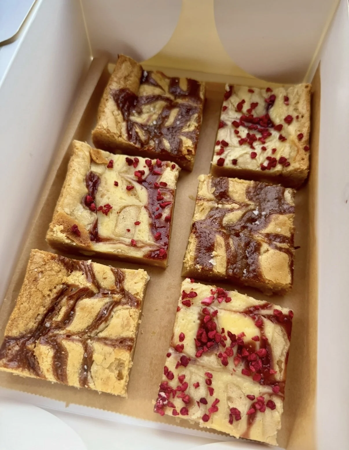A box of six assorted Raspberry cheesecake blondies and salted caramel blondies.