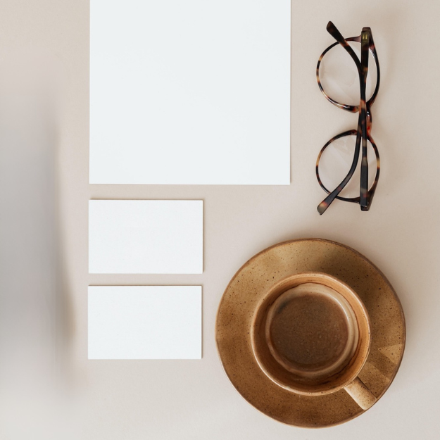 Coffee, glasses and stationery arranged on a minimal desk.