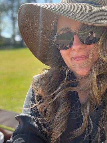Kat, founder of Mellow Office, outdoors on a sunny day.