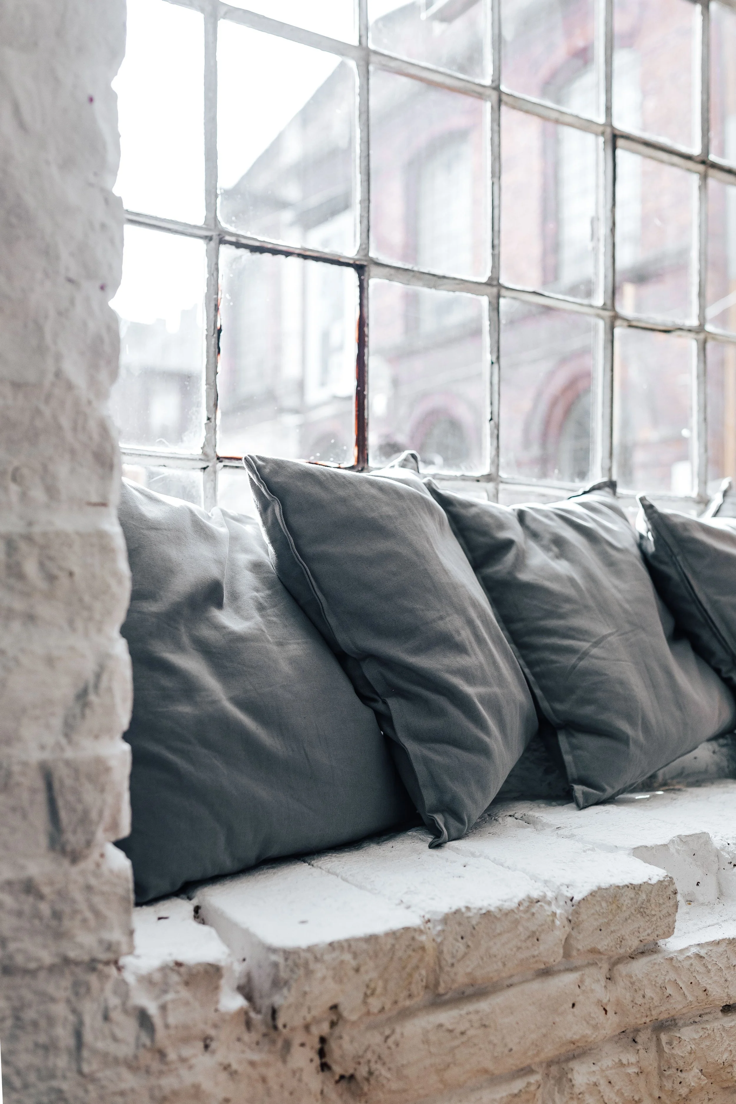 Cozy cushions resting in soft natural light by a window, evoking comfort and calm