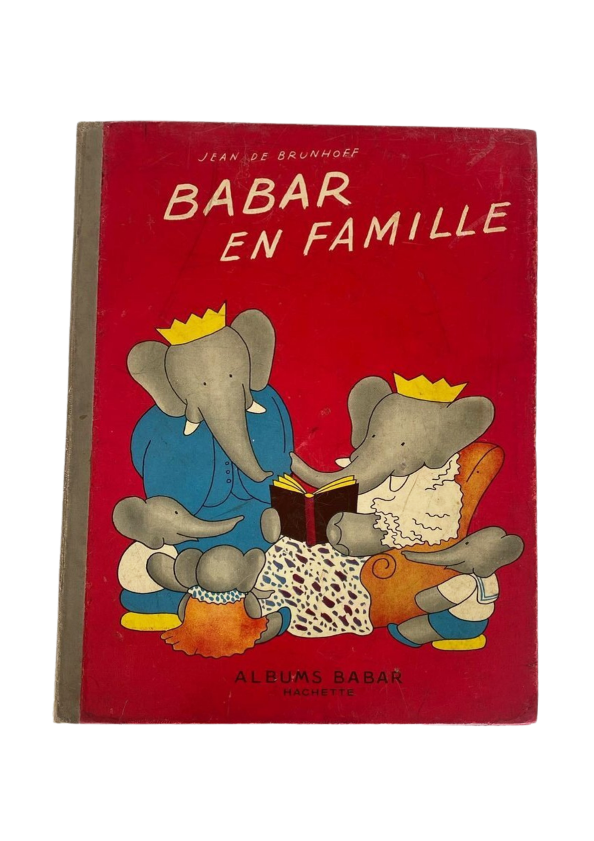 Red book cover titled 'Babar en famille' by Jean de Brunhoff, featuring cartoon elephants in royal clothing reading a book to a young elephant, with an adult elephant seated on a couch.