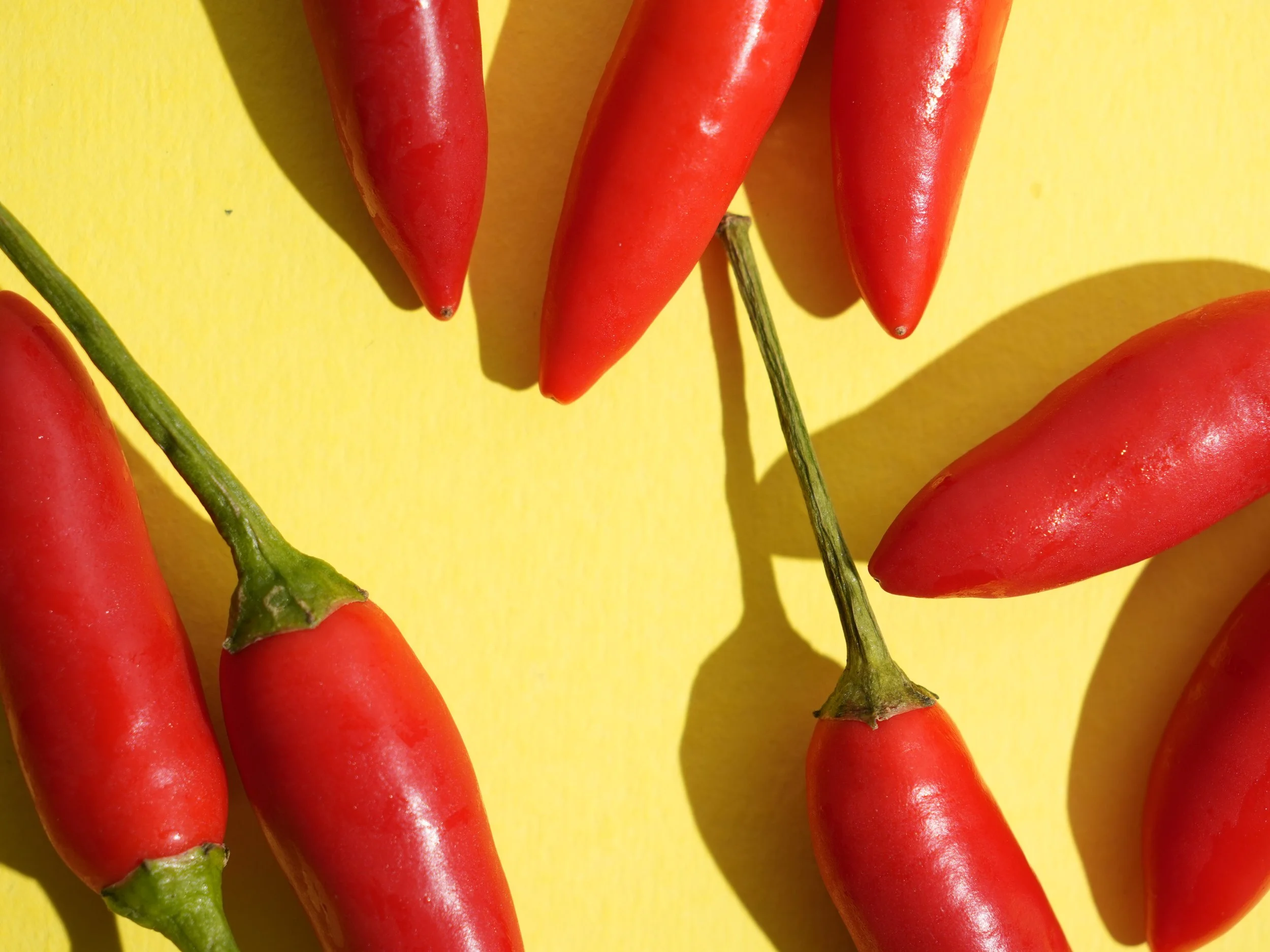 Red chili peppers on a yellow background.