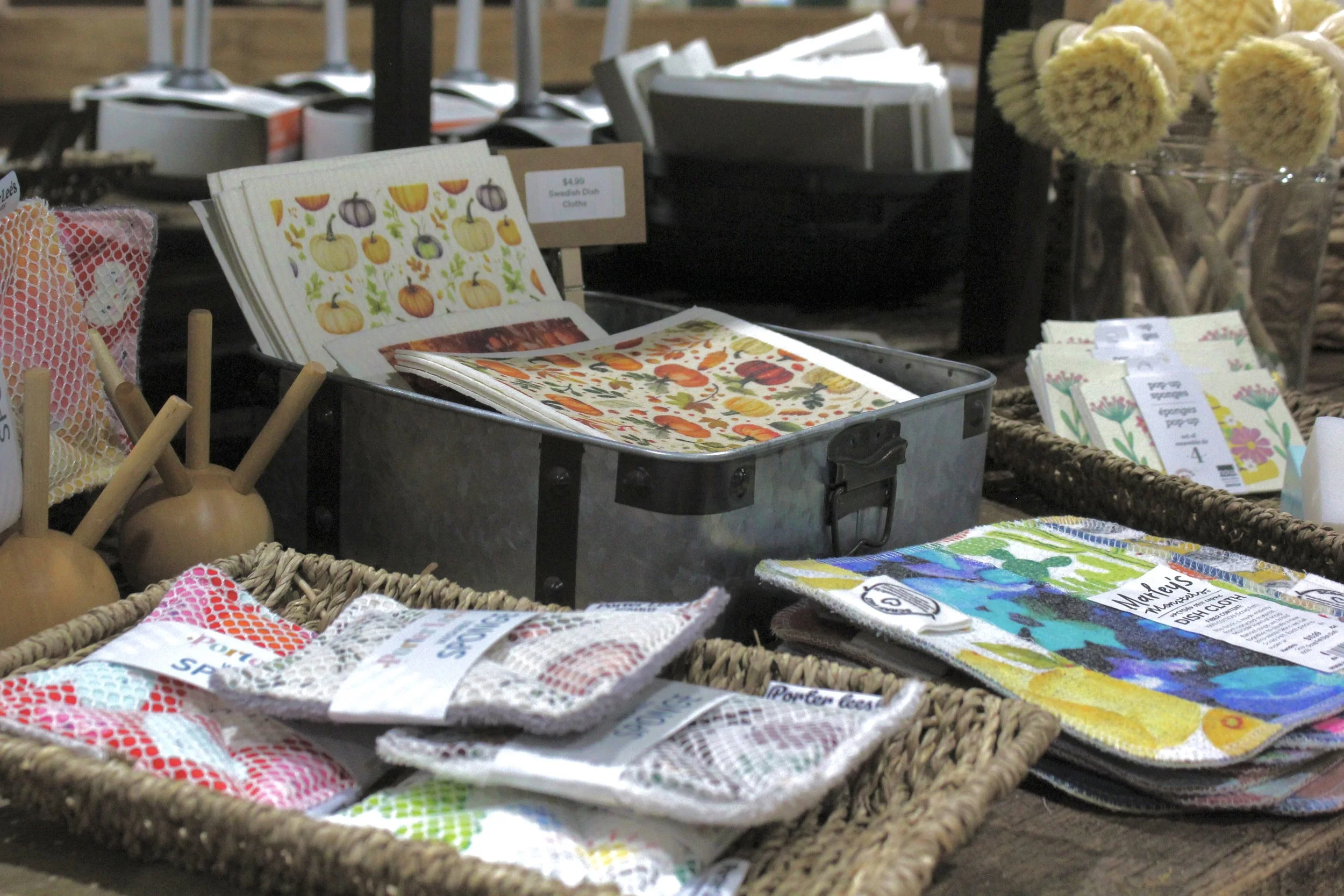 Assorted fabric dishcloths with colorful patterns, displayed in baskets at Burley Sustainable General Store in West Jefferson, NC.