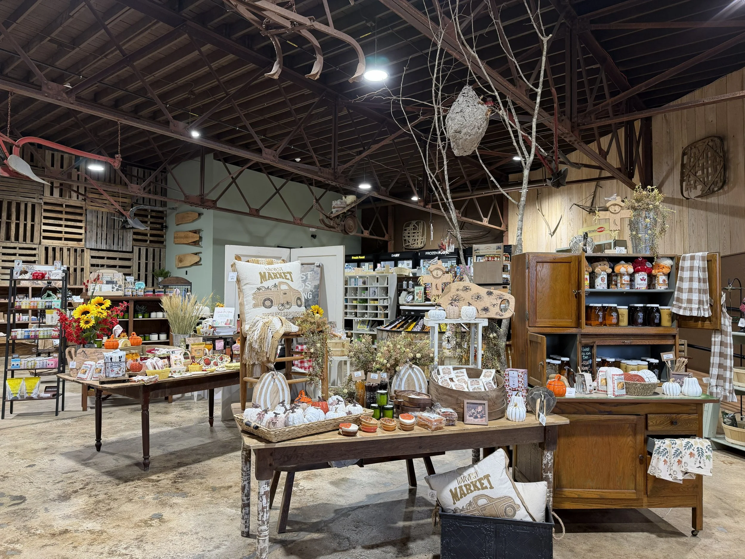 Indoor market display with various fall-themed decorations, candles, and home decor items at Burley Sustainable General Store in West Jefferson, NC.