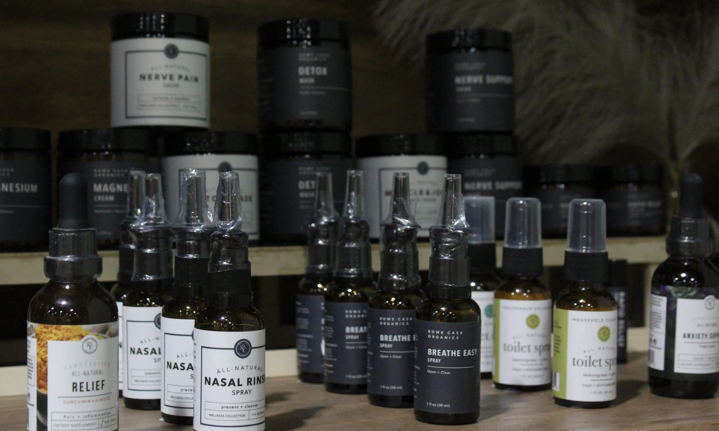 Organic health and wellness products, including bottles labeled nasal spray, breathe spray, toilet spray, and relief spray.