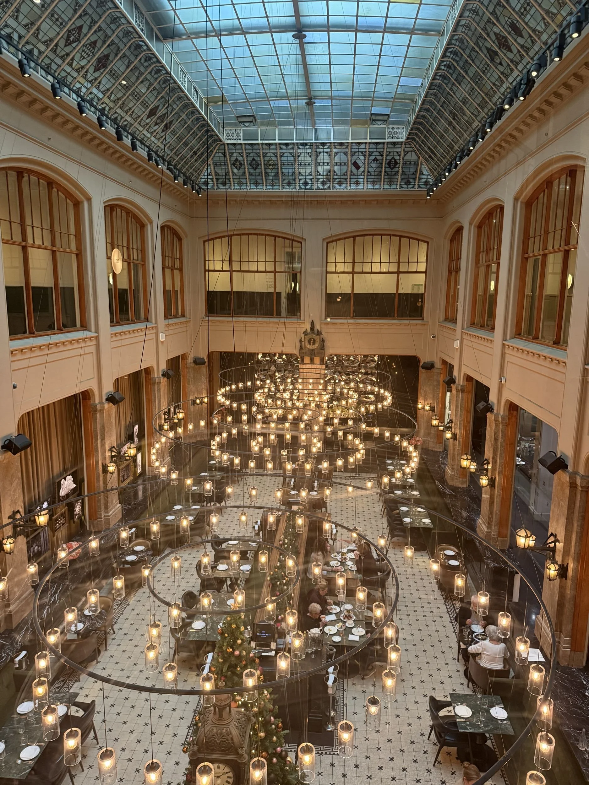 Glass-roofed courtyard lounge of a luxury hotel in Amsterdam