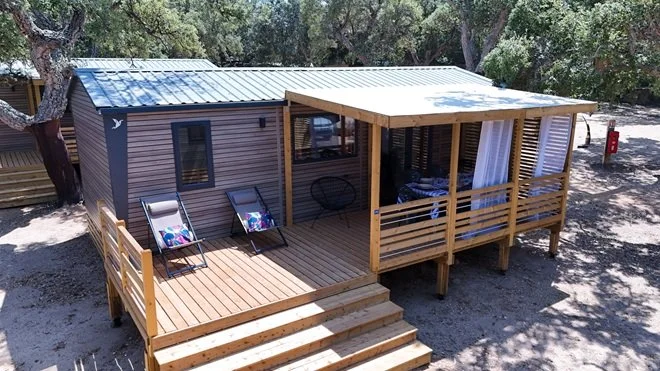 Mobile-home neuf en bois avec terrasse aménagée et transats à Porto-Vecchio