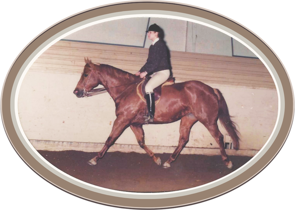 Linda Anne Starr riding a brown horse in indoor riding arena.